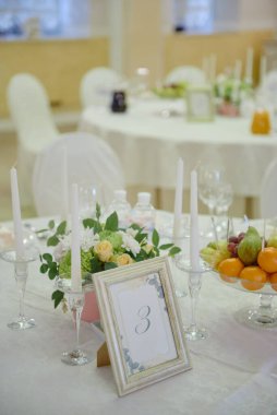 Çiçeklerin çiçek aranjmanı ve vazodaki yeşillik restorandaki düğün masasında, fotokopi odasında. Lüks düğün süslemeleri. Tablo ayarı 