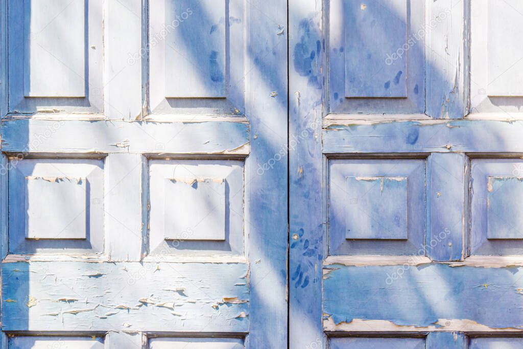 Blue door with squre pattern and peeling paint