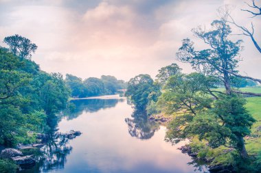 Güneş ışığı, Lune nehrinin Kirkby Lonsdale İngiltere yakınlarındaki köprüden alınışını renklendirir.