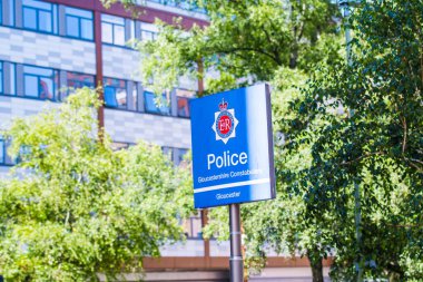 Gloucester Şehri Polis Karakolu tabelası ve ağaçları