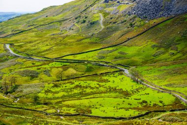 The Struggle road at Kirkstone Pass leading to Windermere lake Ambleside with Snarker Pike of Red Screes mountain on right in Lake District England clipart