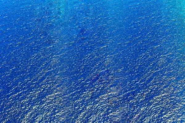 Blau aufgerissenes Wasser mit sonnigen Reflexen. Wasser in plätscherndem Wasser — Stockfoto