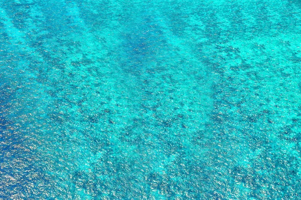 Agua rasgada azul con reflejos soleados. Agua en agua ondulada —  Fotos de Stock