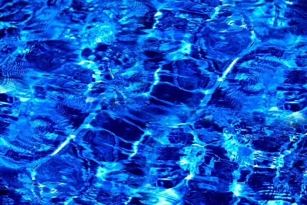 蓝色撕开的水与阳光明媚的反射。波纹水中的水 — 图库照片