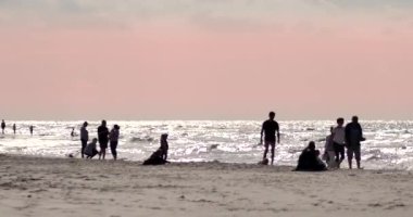 Karwia, Polonya - Tarih: 06232018. İnsanlar rahatlatıcı günbatımı Baltık Denizi beach üzerinde.