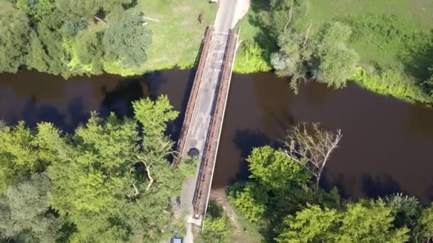 在河上的旧桥空中拍摄 从上面看到的小河流在春天的灯光下 — 图库视频影像