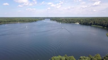 Yazın göl manzarası. Denizde seyreden ve dinlenen insanlar....