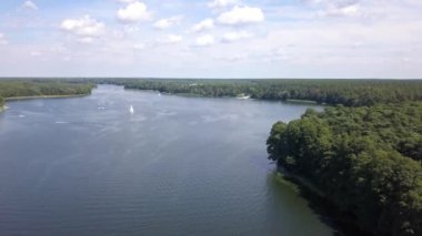 Yazın göl manzarası. Denizde seyreden ve dinlenen insanlar....