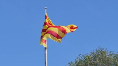 Barselona, İspanya 'da mavi gökyüzü arka planında Katalonya bayrağı dalgalandırmak