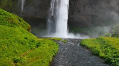 İzlanda 'nın en ünlü şelalesi. Sıcak yaz ışığında görkemli Seljalandsfoss.