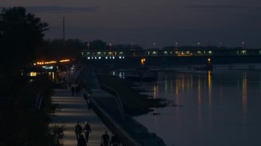 Gezinti güvertesinde tanınmayan insanlar. Varşova 'da Akşam.