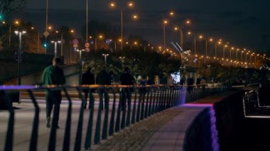 Gezinti güvertesinde tanınmayan insanlar. Varşova 'da Akşam.