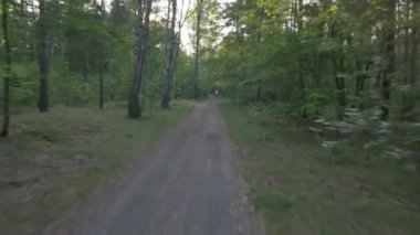 Ormanda bisiklete binen biri. Pürüzsüz uçuş kamerası, spor aktivitelerinin titreşimli görüntüsü.