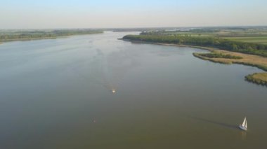 Yazın göl manzarası. Denizde seyreden ve dinlenen insanlar....