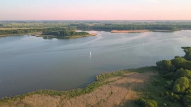 Yazın göl manzarası. Denizde seyreden ve dinlenen insanlar....