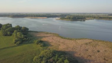 Yazın göl manzarası. Denizde seyreden ve dinlenen insanlar....