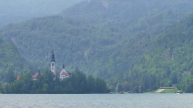 Bled Gölü. Slovenya 'daki dağ gölünün ortasındaki adada güzel bir şapel..