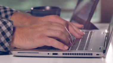 Laptop klavyesinde yazan kişi. Laptop 'ta çalışırken sabah kahvesi..