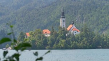 Bled Gölü. Slovenya 'daki dağ gölünün ortasındaki adada güzel bir şapel..