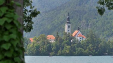 Bled Gölü. Slovenya 'daki dağ gölünün ortasındaki adada güzel bir şapel..