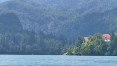 Bled Gölü. Slovenya 'daki dağ gölünün ortasındaki adada güzel bir şapel..