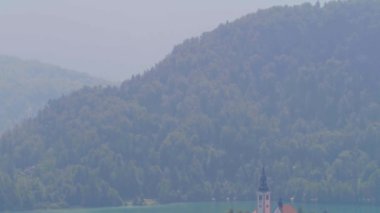 Bled Gölü. Slovenya 'daki dağ gölünün ortasındaki adada güzel bir şapel..