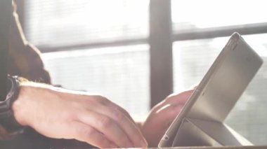 Tablet kullanan bir adam. Tablet üzerinde çalışan kişinin görüntülerini kapat.