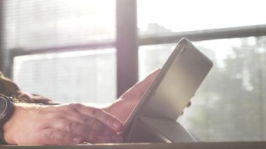 Tablet kullanan bir adam. Tablet üzerinde çalışan kişinin görüntülerini kapat.