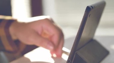 Tablet kullanan bir adam. Tablet üzerinde çalışan kişinin görüntülerini kapat.