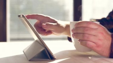 Tablet kullanan bir adam. Tablet üzerinde çalışan kişinin görüntülerini kapat.