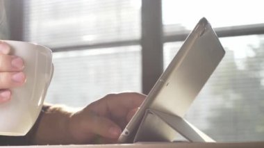 Tablet kullanan bir adam. Tablet üzerinde çalışan kişinin görüntülerini kapat.