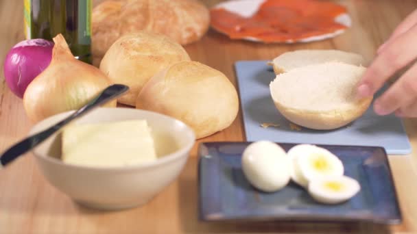 朝食に卵とスモークサーモンのサンドイッチを用意する者 — ストック動画