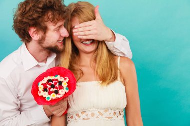 Yakışıklı adam kadın şeker demet çiçek vererek. Genç erkek ile kız gözlerini kapsayan için sürpriz hediye hediye. Mutlu sevgi dolu çift. Aşk.