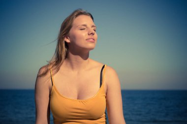 Tatil, yaz ve özgürlük kavramı. Güzel sarışın kız güneşli rüzgarlı gün zevk deniz kenarında açık rahatlatıcı