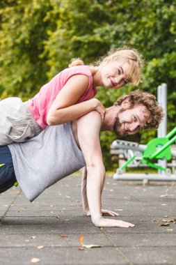 Aktif genç adam ve kadın yapıyor egzersiz push up. Kas güçlü adam ve kız eğitimdeki açık spor salonunda çalışma dışarı uygun. Spor fitness ve sağlıklı yaşam konsepti.