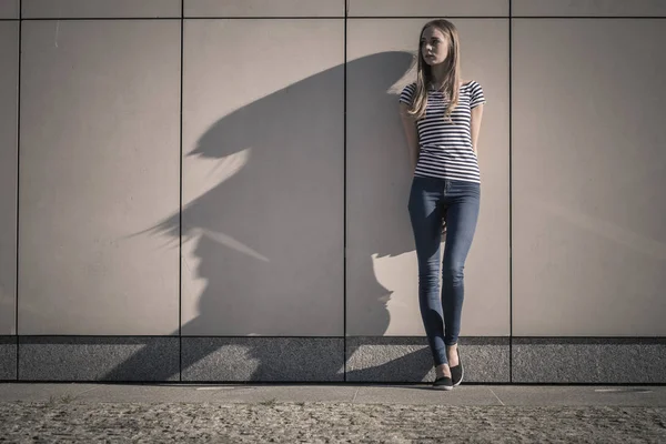 全長石グランジ壁にカジュアルなスタイルで若いブロンドの女性 — ストック写真