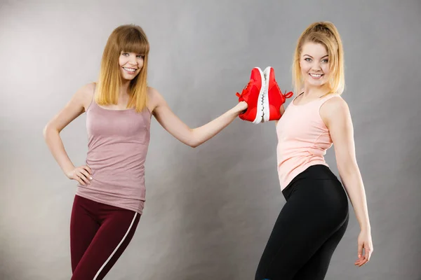 Deux Femmes Souriantes Heureuses Présentant Des Chaussures Rouges Pour Entraîneurs — Photo