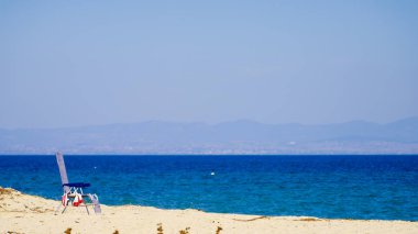 Bir tek şezlong boş kum plajındaki. Deniz gevşeme yerini.