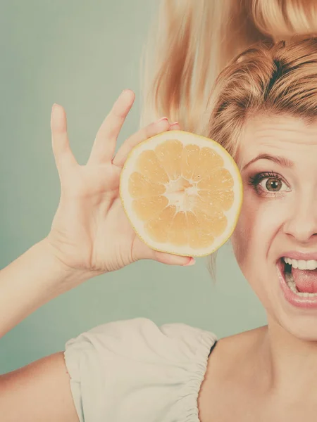 Healthy diet, refreshing food full of vitamins. Woman holding sweet delicious citrus fruit, green grapefruit.