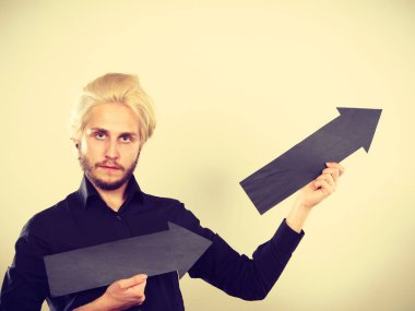 Planlama, yön, seçimler kavramı. Aynı yönde iki siyah oklar tutan adam. Açık renkli üzerinde kapalı atış