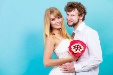 Şeker ile mutlu sevgi dolu çift bir buket çiçek grup. Yakışıklı adam ve tutan güzel kadın hediye. Aşk kavramı.