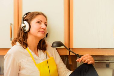 Mutfakta sakin ol. Müzik dinleme. Düşünme rüya ev kadını aşçı Şef sarı önlük oturma ve rahatlatıcı evde giyen kulaklık ile.