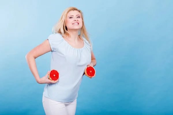 女人握在手 在蓝色的两半的红葡萄柚柑橘类水果的小女孩微笑着 健康减肥食品 暑假里有趣的概念 — 图库照片