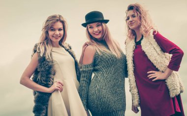 Üç modaya uygun kadın şık kıyafetler giyiyorlar. Tarz, moda, arkadaşlık konsepti.