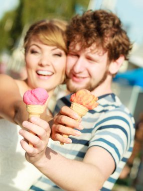 Yaz tatili ve mutluluk konsepti. Şehirde dondurma yiyen genç bir çift.