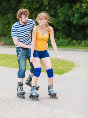 Bayram, aktif insanlar ve dostluk kavramı. Açık havada, kadın ve erkek paten birlikte şehir sokak üzerinde sürme paten üzerinde çift genç yerleştirmek