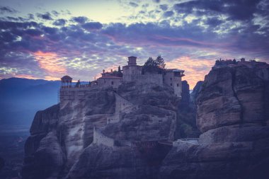 Meteora, Thessaly Yunanistan 'daki kutsal Varlaam Manastırı' nın üzerinde gün batımı manzarası. Yunan varış noktaları