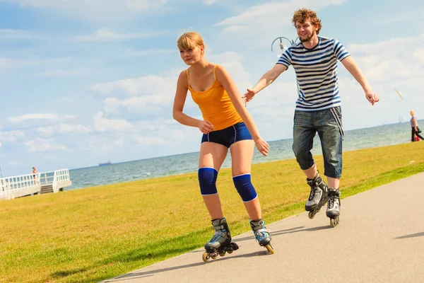 활동적 방식의 사람들 남녀가해 안에서 야외로 롤러스케이트를 여자와 남자가 즐거운 — 스톡 사진