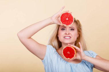 Sağlıklı beslenme, vitamin dolu ferahlatıcı yiyecekler. Mutlu kadın elinde tatlı narenciye, kırmızı greyfurt tutuyor..