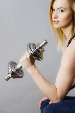 Güçlü kadın dumbell ağırlık kaldırma. Bina kas kazanma çekici sarışın model kız egzersiz uygun. Fitness ve vücut geliştirme, Grey